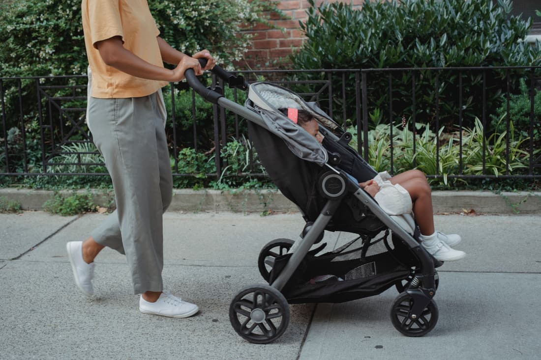 A premium stroller being pushed along a city sidewalk