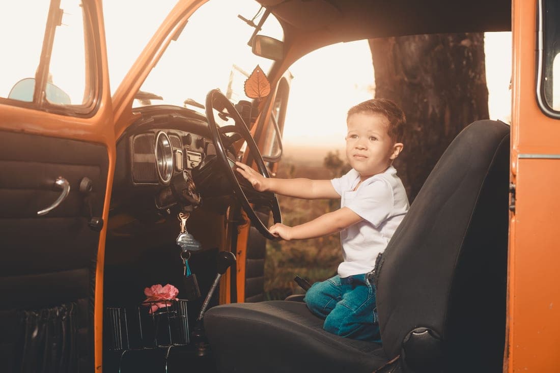 A school-age child buckled into a booster seat with a vehicle seat belt