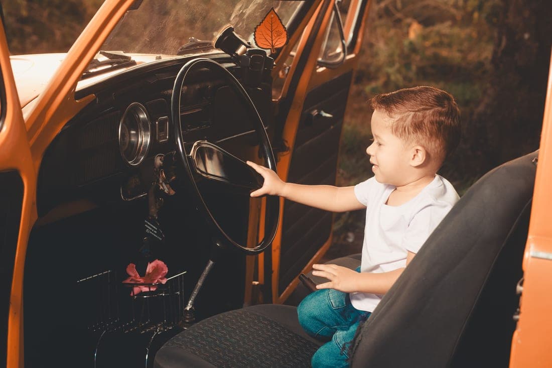 A toddler buckled into a forward-facing car seat