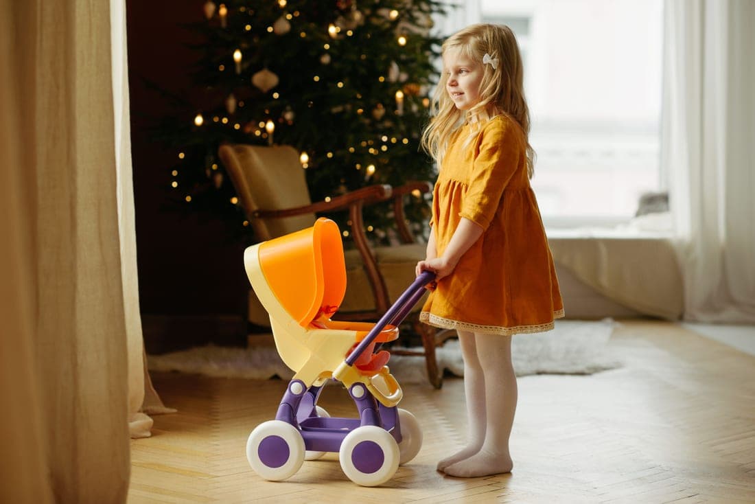 A folded stroller standing upright on its own