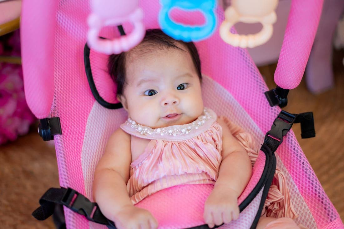 A newborn secured in a rear-facing infant car seat carrier