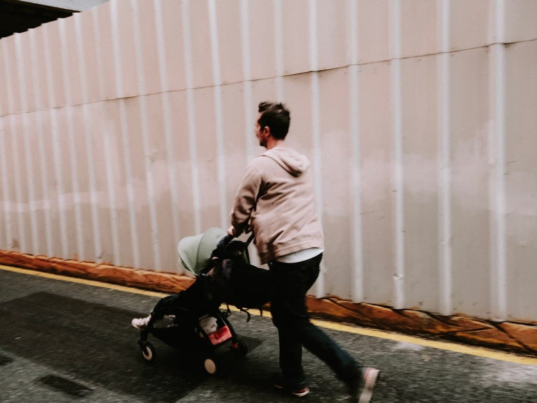 A compact folded stroller being carried in one hand