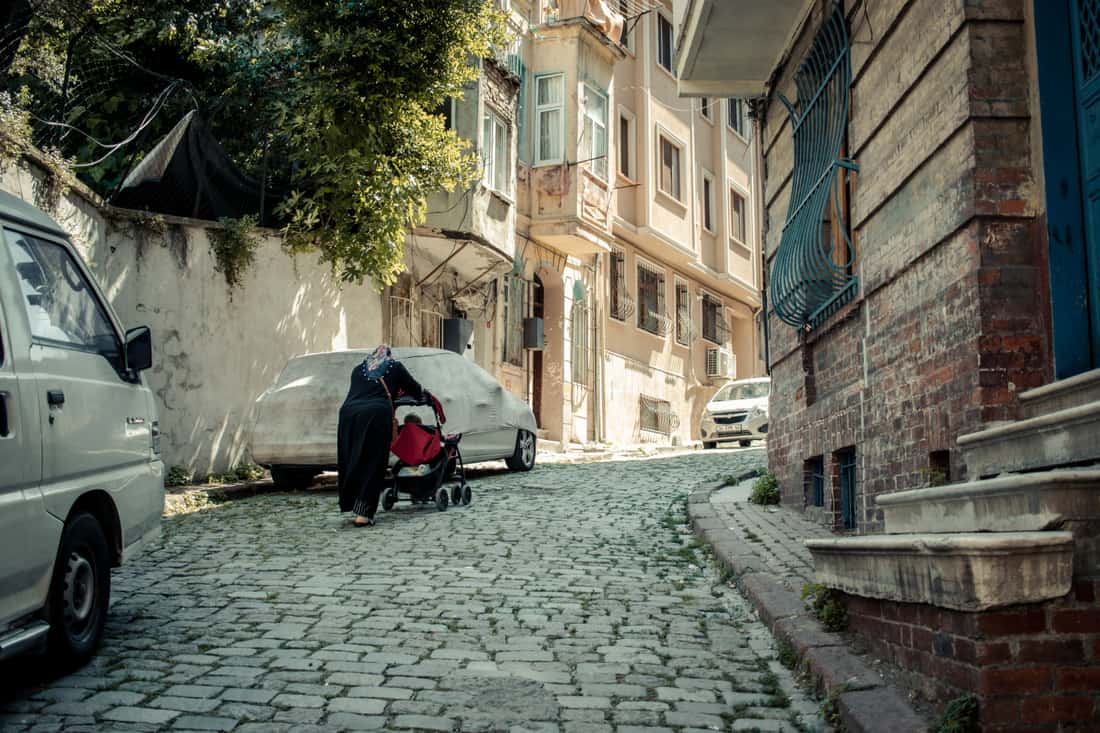 A compact stroller and infant car seat combination on a city street