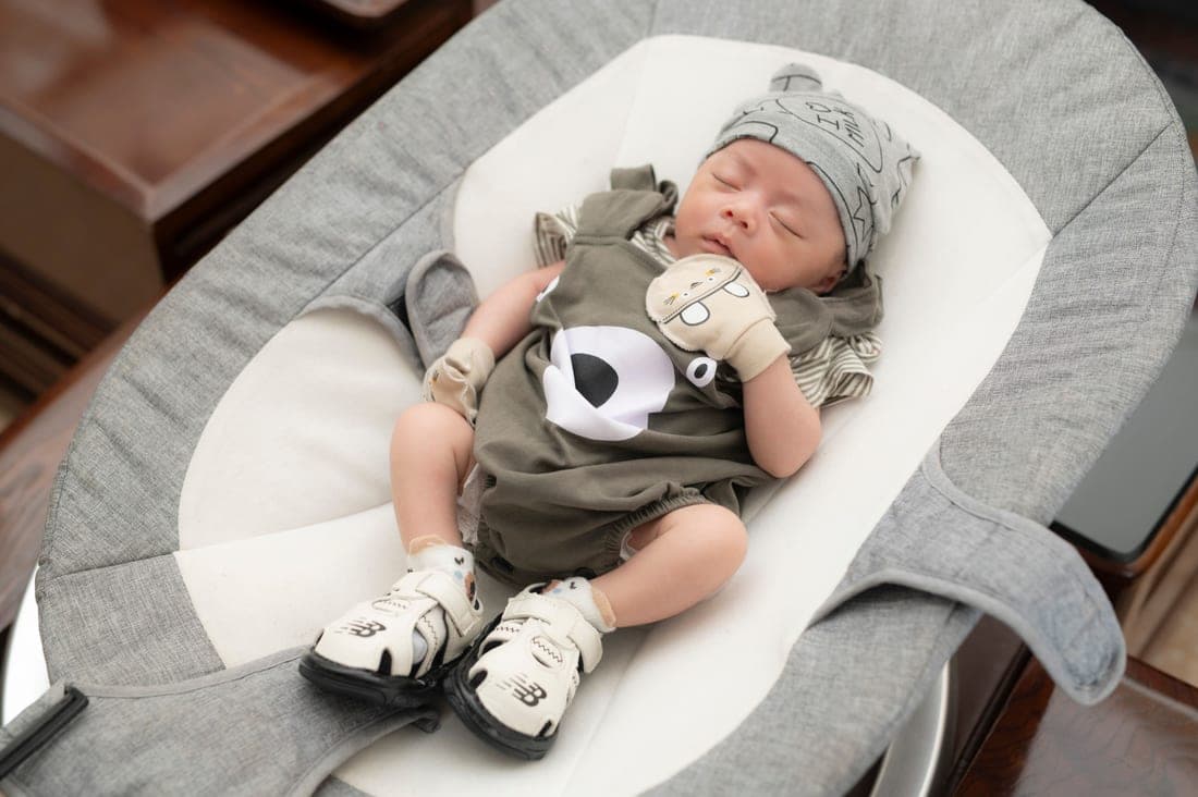 A sleeping infant in a car seat carrier