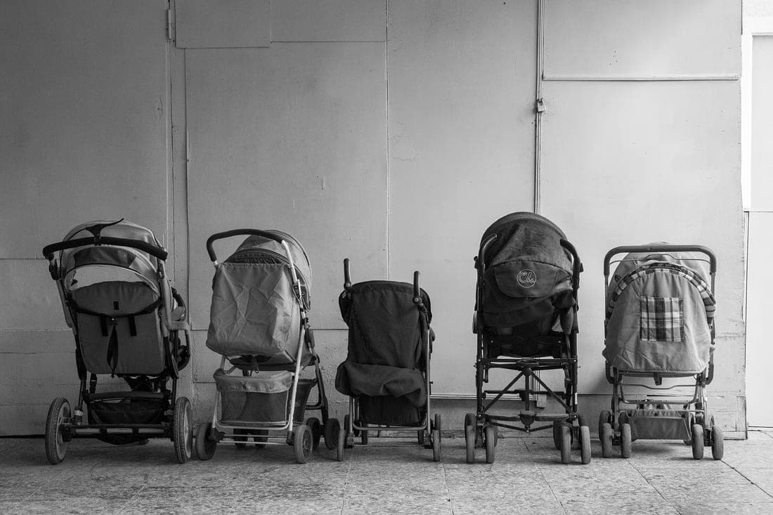 A row of strollers on display in a baby shop