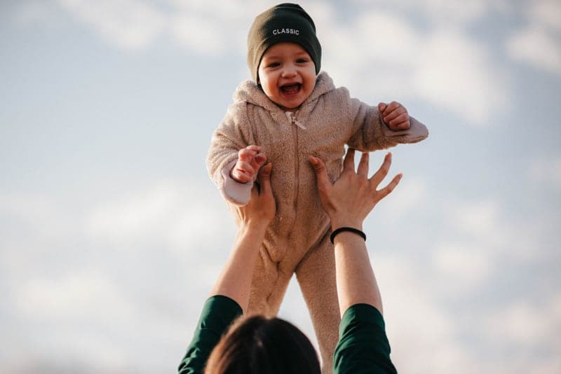 A child being lifted into a car seat through an open door — category photo, not this specific model